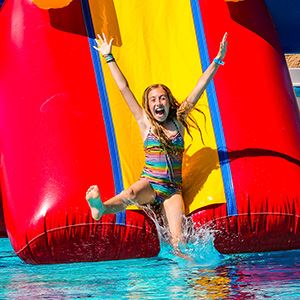 girl going down inflatable pool slide