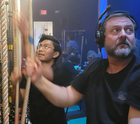 Crew members Jon Baker and Noah Monje run the rail for a performance